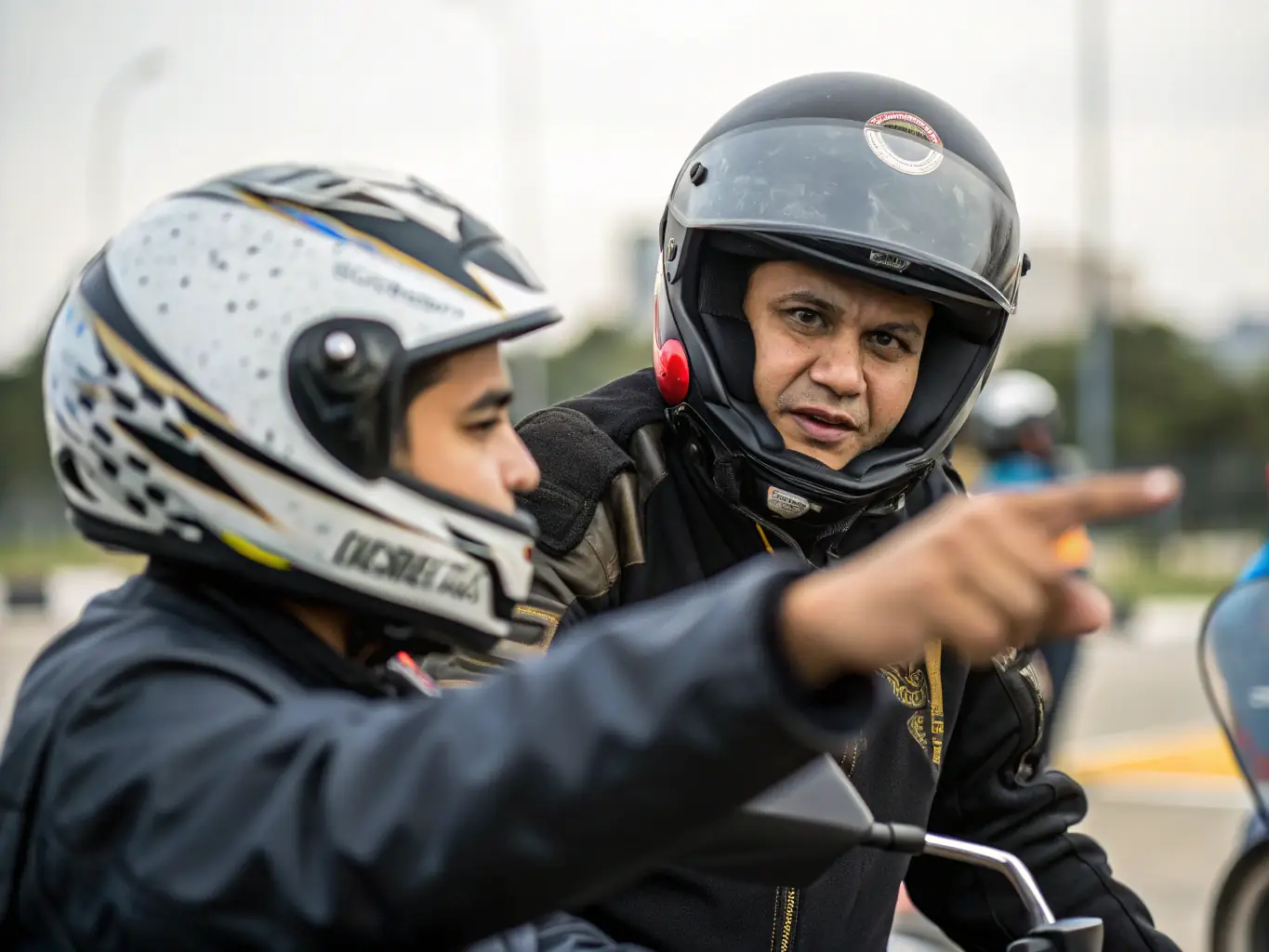 A photo of participants in a motor sports training session, focusing on the instructor demonstrating proper riding techniques and safety protocols.